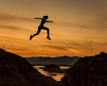 donna che fa salto al tramonto